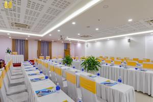 a banquet hall with white tables and yellow chairs at Merry Land Hotel Da Nang in Danang +37 photos