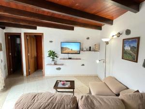 ein Wohnzimmer mit einem Sofa und einem Tisch in der Unterkunft Sun, Relax & Lava, Free wifi 600mb, BBQ in Tinajo