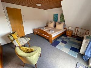 a small bedroom with a bed and a chair at Apartment Moselblick in Ürzig