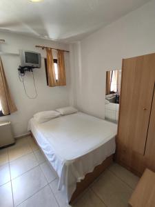 a small bedroom with a bed and a tv at Studios Kapsalas Thessaloniki in Thessaloniki