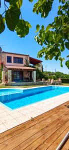 a swimming pool in front of a house at Villa Skine with private pool and garden in Chania Town