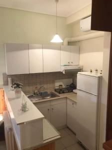 a kitchen with white cabinets and a sink and a refrigerator at AFISSOS-DREAM 3STUDIOS in Afissos +52 photos