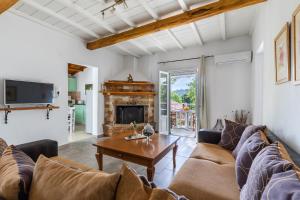 a living room with a couch and a table at Skopelos Amigdalia cottage in Skopelos Town