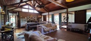 a large living room with couches and a piano at Pousada na Cervejaria Altezza - vista para Pedra Azul in Venda Nova do Imigrante