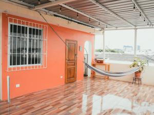 a hammock in a room with an orange wall at Suite con terraza amplia in Guayaquil