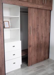 a closet with a wooden door and white drawers at Suite con terraza amplia in Guayaquil