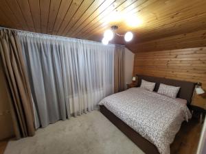 a bedroom with a bed and a wooden ceiling at Вила Пенчеви, кк. Цигов чарк in Tsigov Chark +25 photos