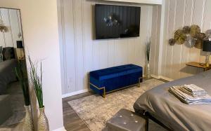 a living room with a blue stool and a tv at Cozy and Modern 1BR Apartment with WiFi and Dogs Welcome in Baltimore
