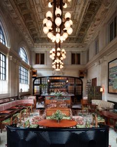 a large room with tables and chairs and a chandelier at Nine Orchard in New York