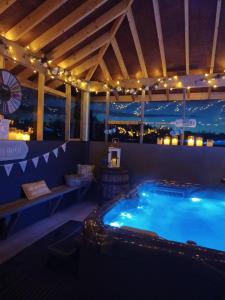 a swimming pool at night with a view of the city at Nesswood Luxury Glamping in Derry Londonderry