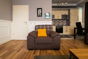 a living room with a couch with a yellow pillow at CedarTREE Prishtina in Prishtinë