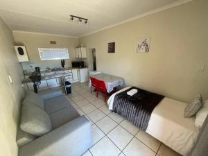 a living room with a couch and a kitchen at Marikal Guesthouse in Upington