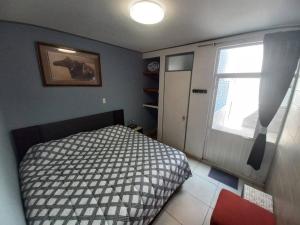 a small bedroom with a bed and a window at Apartamento a minutos caminando del Aeropuerto CDMX Terminal 1 in Mexico City