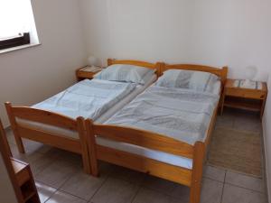 a bedroom with two beds and two night stands at Apartmani Hotko in Sveti Juraj