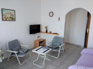 a living room with two chairs and a table and a tv at Apartmani Hotko in Sveti Juraj