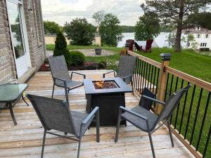 een terras met stoelen en een tafel met een vuurplaats bij Rock Hill Bed & Breakfast in Sharbot Lake