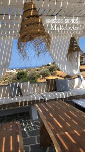 a wooden bench sitting under a white pergola at Nissos Suites in Apollonia