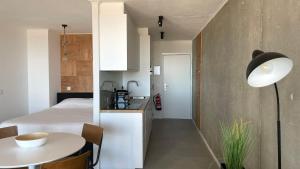 a room with a bed and a table and a kitchen at Sea Shelter in Ostend