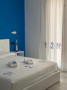 a bedroom with two beds and a blue wall at Residenza “La Vecchia Ancora” in Castelsardo