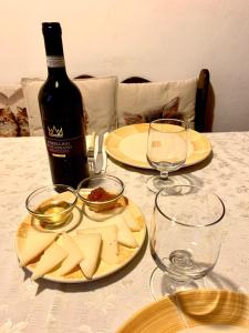 PignanoにあるAgriturismo Santa Brunaのチーズ2皿とワイン1本付きのテーブル