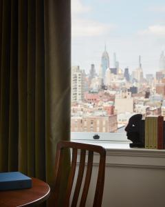 a chair and a window with a view of a city at Nine Orchard in New York
