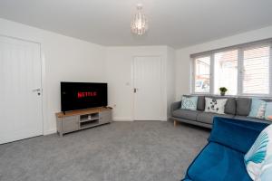 a living room with a couch and a tv at Oulton Broads New Build Holiday Home 3 Bedroom- 3 Bathroom with Free Parking in Flixton
