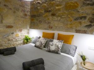 a bedroom with a large bed with a stone wall at Chic Gran Vía, nuevo apartamento de diseño en Gros by ChicDonosti in San Sebastián
