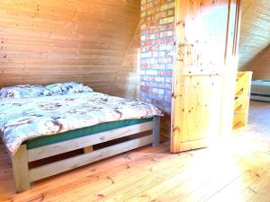 a bedroom with a bed and a wooden wall at Oliwkowy gaj in Sasino