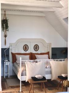1 dormitorio con cama blanca y almohadas blancas en Vulkán Nyúlontúl, en Mencshely