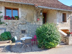 een tafel en stoelen voor een stenen huis bij Gîte 11 personnes avec extérieur in Saint-Maurice-de-Rotherens