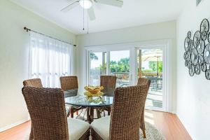 a dining room with a glass table and chairs at You can't get closer to the beach than this beachy 3 bedroom condo in Siesta Key