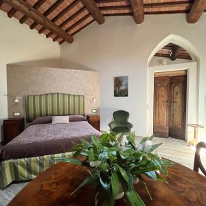 Un dormitorio con una cama y una mesa de madera. en Agriturismo Villa La Fontina, en Castiglion Fiorentino