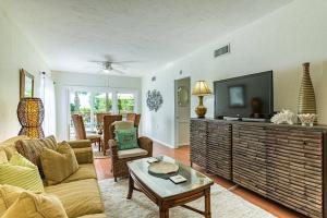 a living room with a couch and a flat screen tv at You can't get closer to the beach than this beachy 3 bedroom condo in Siesta Key