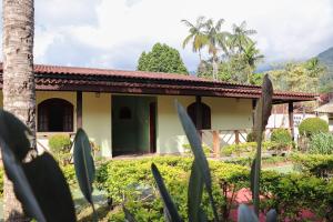 dom z ogrodem przed nim w obiekcie Casa de temporada Refugio das Aguias w mieście Ubatuba