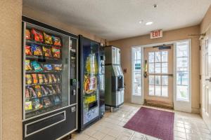 a convenience store with two refrigerators and food at HomeTowne Studios & Suites by Red Roof Charlotte - Concord in Concord