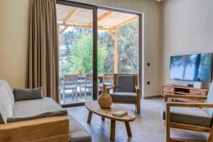 a living room with a couch and a tv at Kavos beach house in Pefki