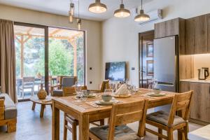 Kavos beach house في بيفكي رودس: مطبخ وغرفة طعام مع طاولة وكراسي خشبية
