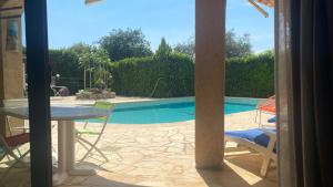 a view of a pool from a patio with a table and chairs at 2 Pièces Rdc Villa Piscine in La Roquette-sur-Siagne