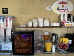 a counter with a refrigerator with food and drinks at Super 8 by Wyndham Trinidad in Trinidad