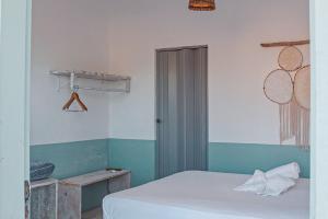 1 dormitorio con cama blanca y pared verde y blanca en CasaMar Guriú en Guriú