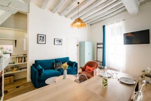 een woonkamer met een tafel en een blauwe bank bij Le Mont Brenn in Auxerre