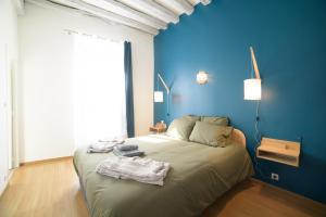 um quarto azul com uma cama com toalhas em Le Mont Brenn em Auxerre
