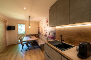una cucina con lavandino e tavolo in una stanza di Das Lindtal - Appartements a Finkenberg