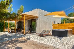 a house with a patio with a television and an umbrella at Kavos beach house in Pefki Rhodes
