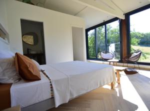 a bedroom with a bed and a large window at Chambre d'hôtes A la clé des champs Varen in Varen