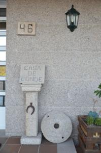 una señal en el lateral de un edificio de piedra con una alegría en Casa de Conde, en Coirón