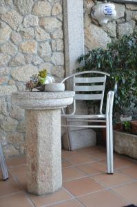 un banco de piedra sentado junto a una pared de piedra en Casa de Conde, en Coirón