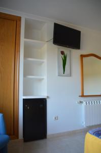Pokój ze ścianą z telewizorem i półkami w obiekcie Casa de Conde w mieście Coirón
