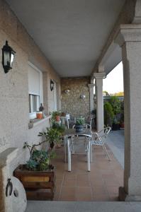 patio ze stołem i krzesłami na ganku w obiekcie Casa de Conde w mieście Coirón