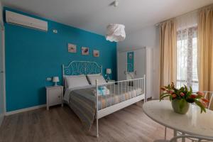 Dormitorio azul con cama y mesa en B&B Villino Giovanna, en Porto SantʼElpidio